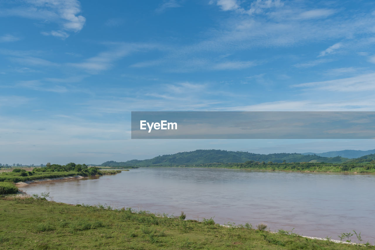 SCENIC VIEW OF LAND AND LAKE AGAINST SKY