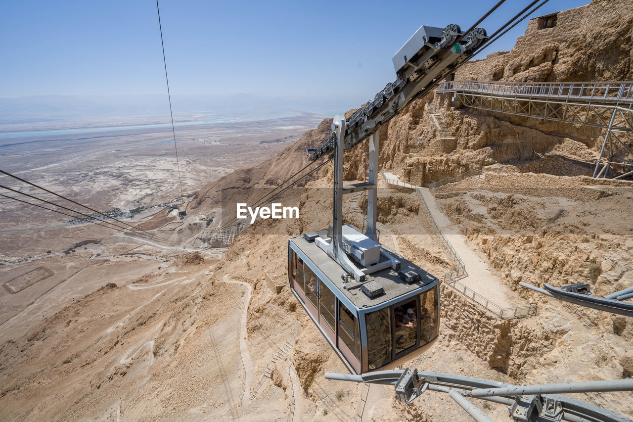 Yellow cableway start descent from masada fortress on sunny day israel