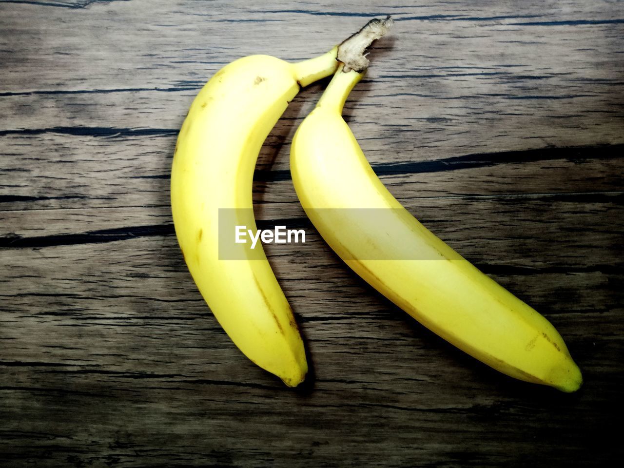HIGH ANGLE VIEW OF BANANAS ON WOODEN TABLE
