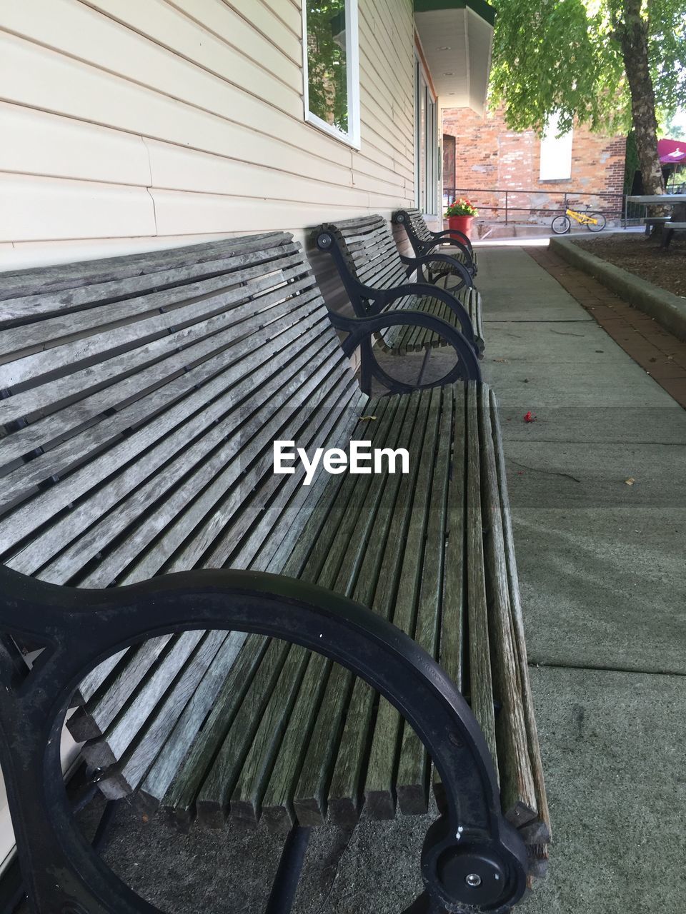 CLOSE-UP OF BICYCLE PARKED IN FRONT OF EMPTY BENCH