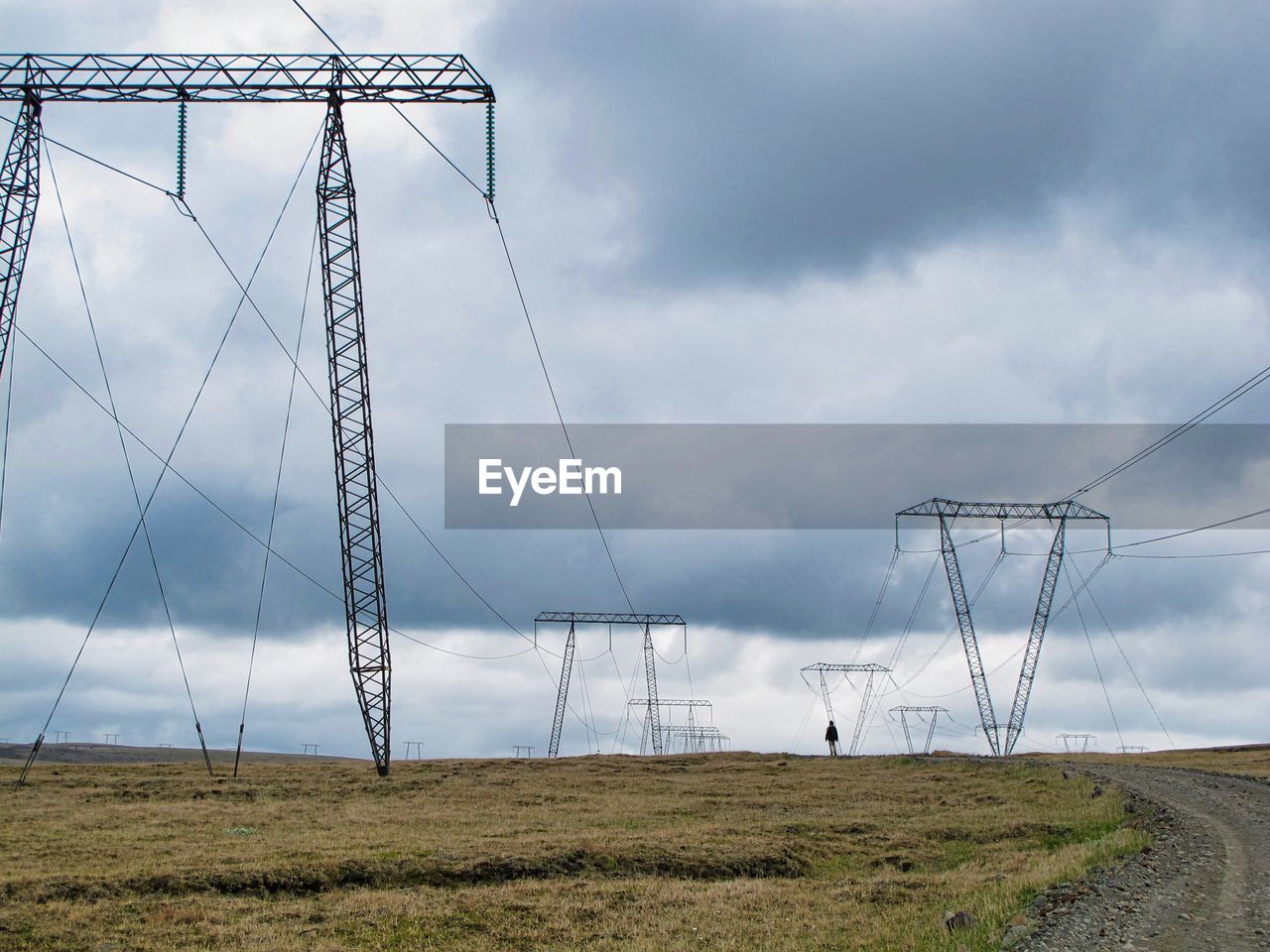 Electricity pylon on field against sky