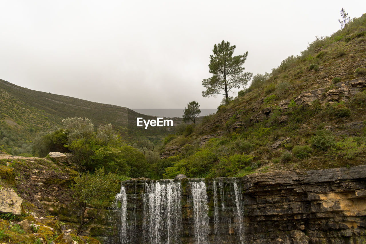 Scenic view of waterfall against sky