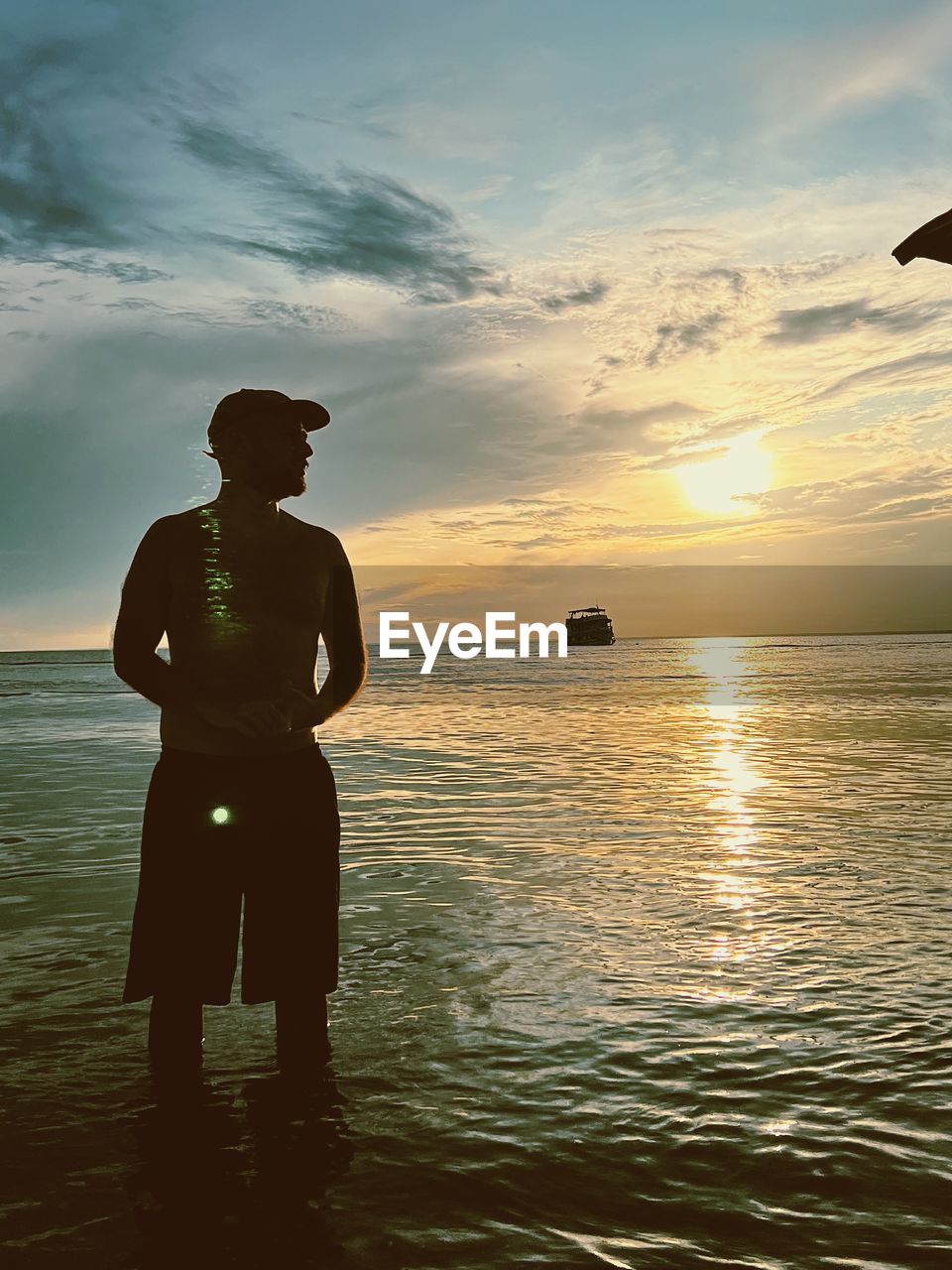 water, sky, sea, sunset, nature, ocean, one person, silhouette, beach, beauty in nature, land, men, adult, cloud, standing, coast, reflection, sunlight, scenics - nature, horizon, vacation, horizon over water, outdoors, trip, leisure activity, sun, person, tranquility, holiday, full length, occupation, travel, lifestyles, dusk, shore, three quarter length, tranquil scene