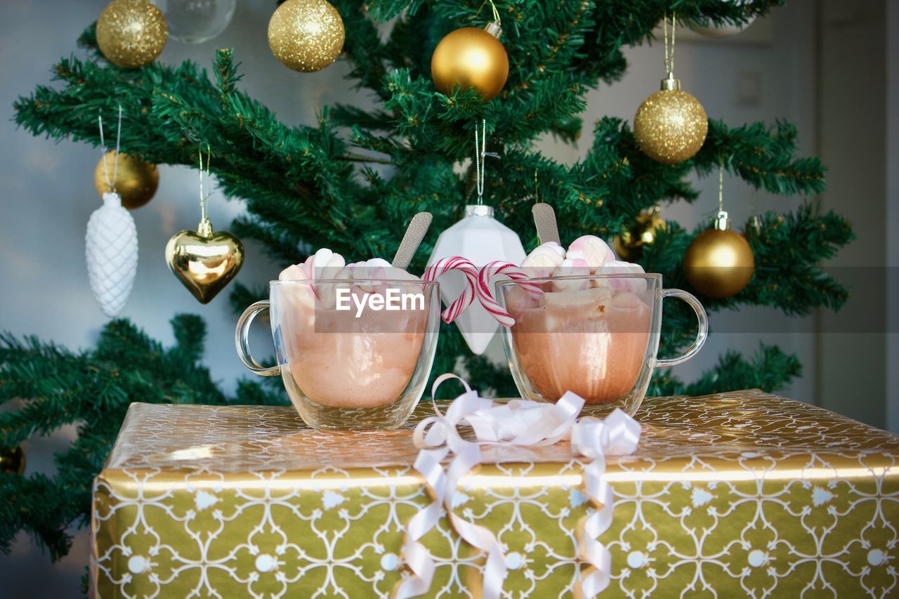 Close-up of drinks on table by christmas decorations