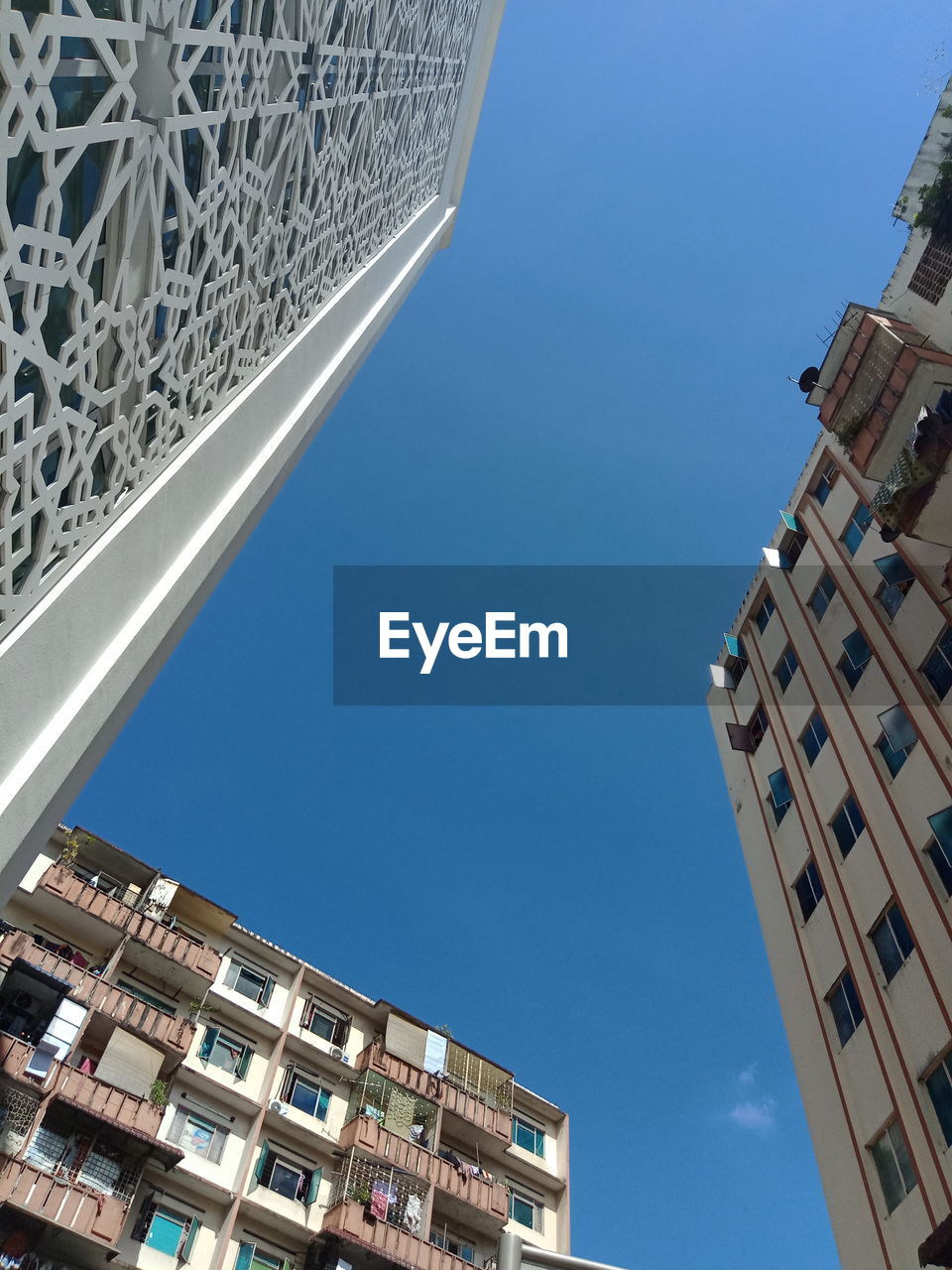 LOW ANGLE VIEW OF BUILDINGS AGAINST BLUE SKY