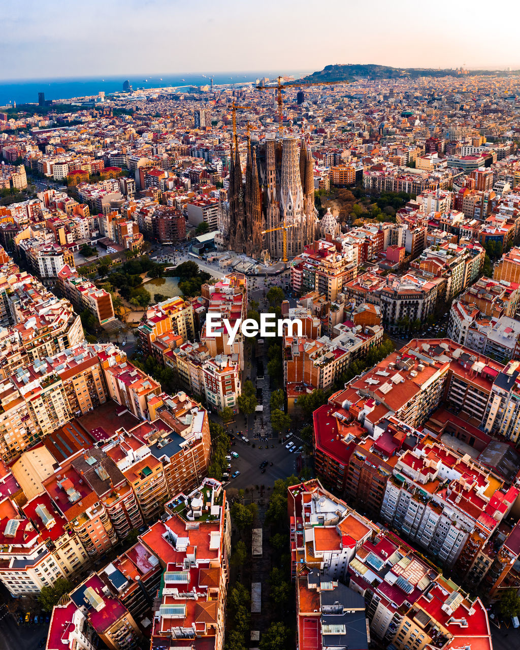 HIGH ANGLE VIEW OF CITY BUILDINGS AGAINST CLOUDY SKY