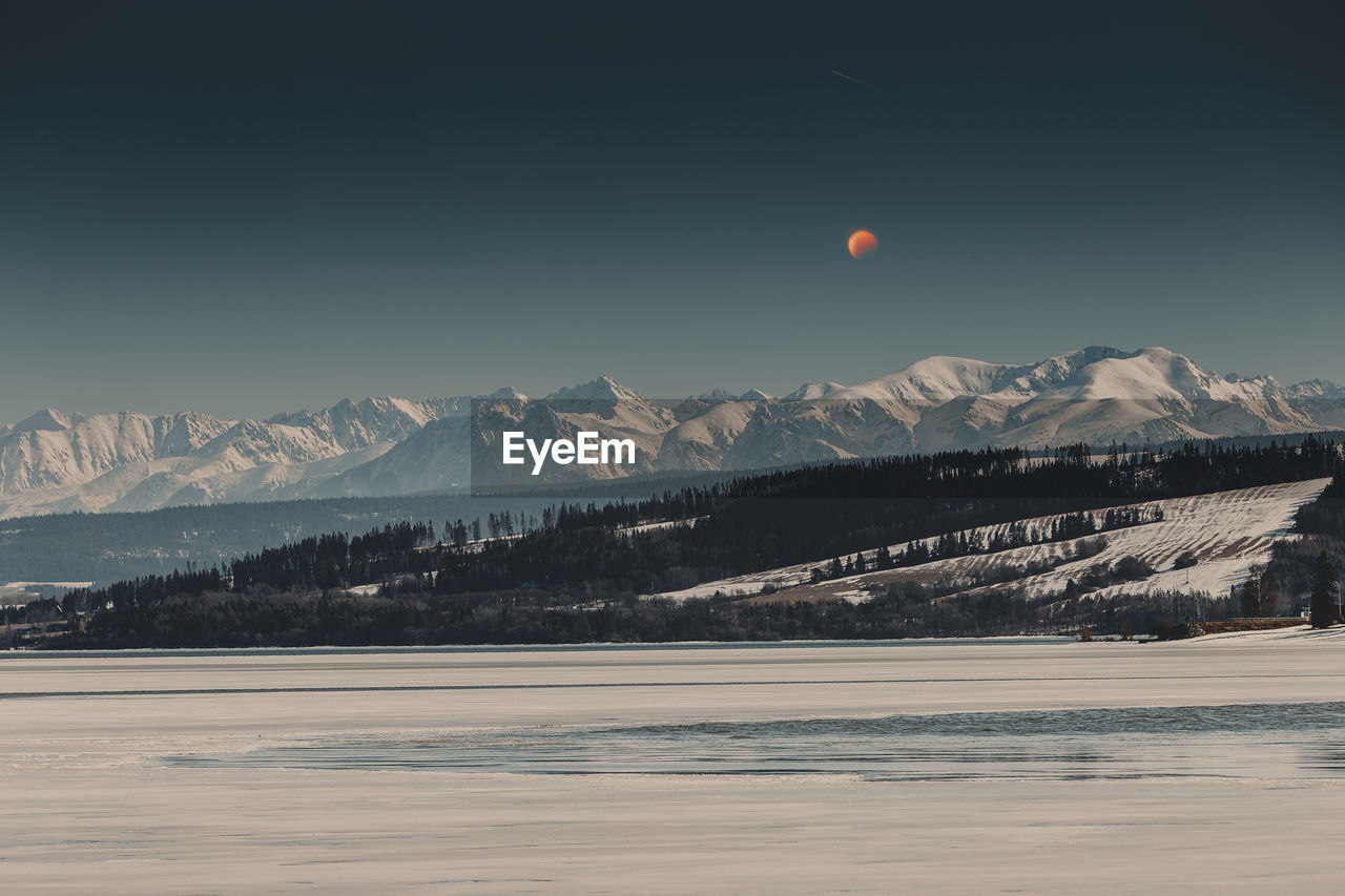 Scenic view of snowcapped mountains against sky during sunset