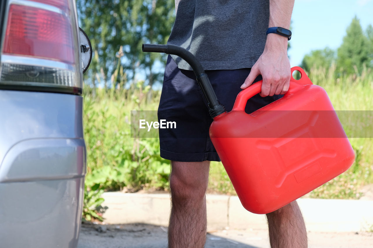 low section of man cleaning car on street