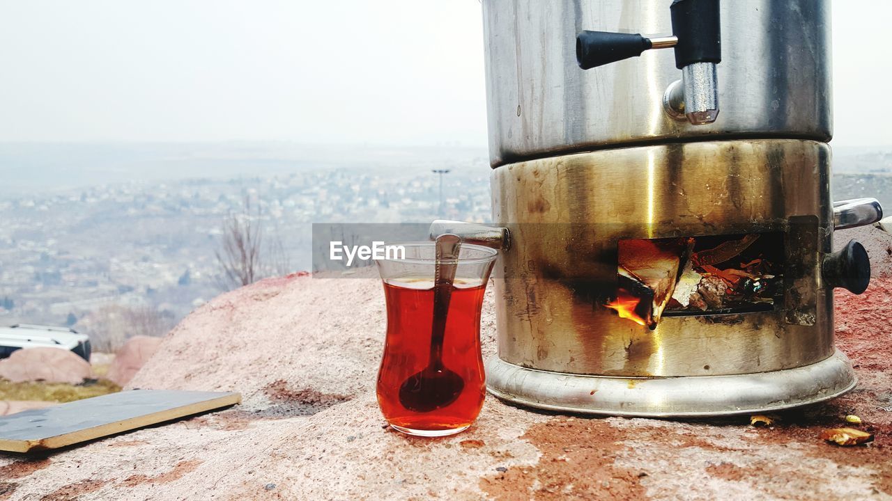 Turkish in tea glass by camping stove on rock