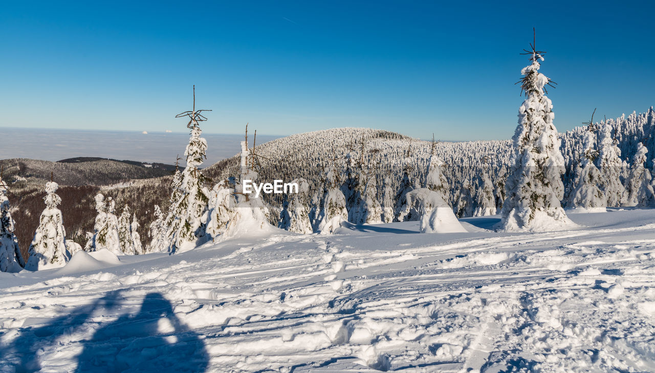 SNOW COVERED LAND AGAINST SKY