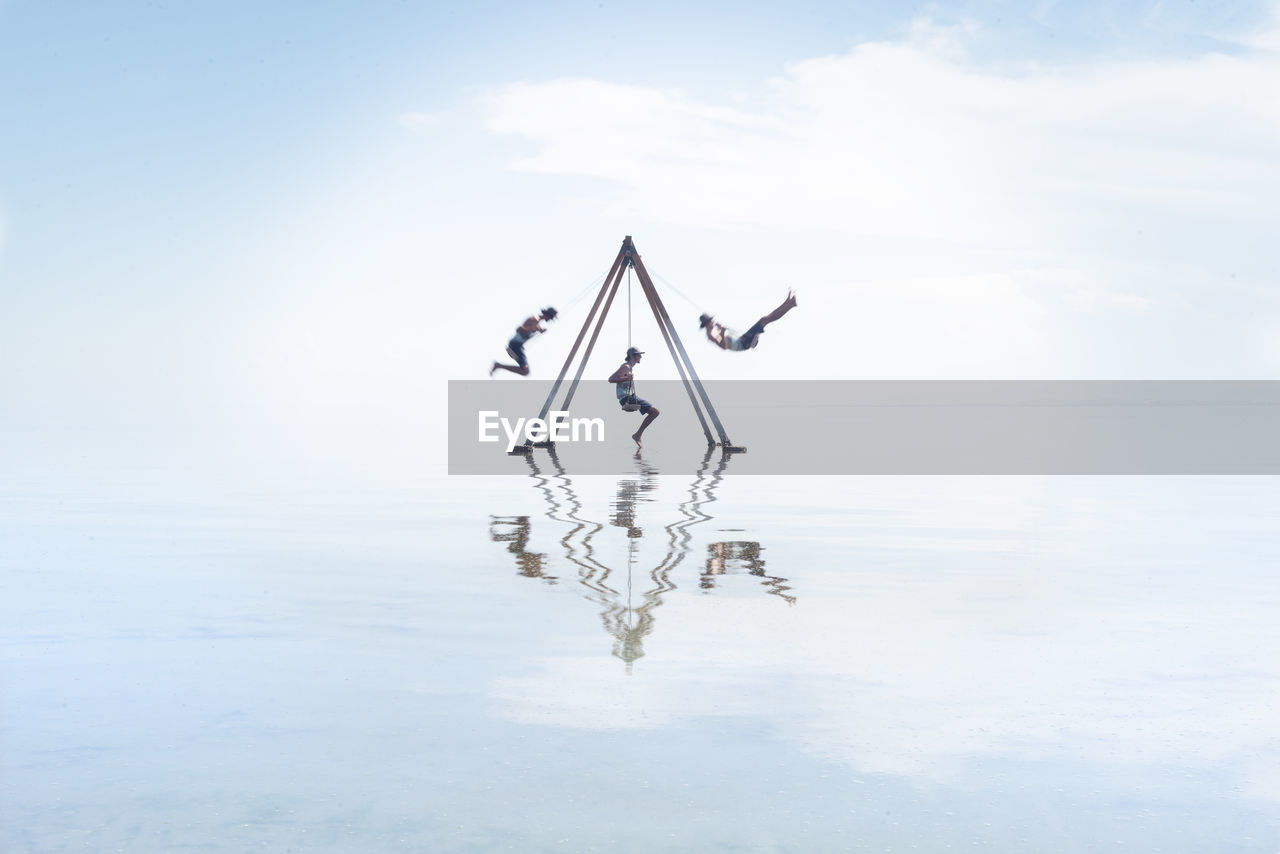 Self portrait on swing set in reflection on salton sea californi