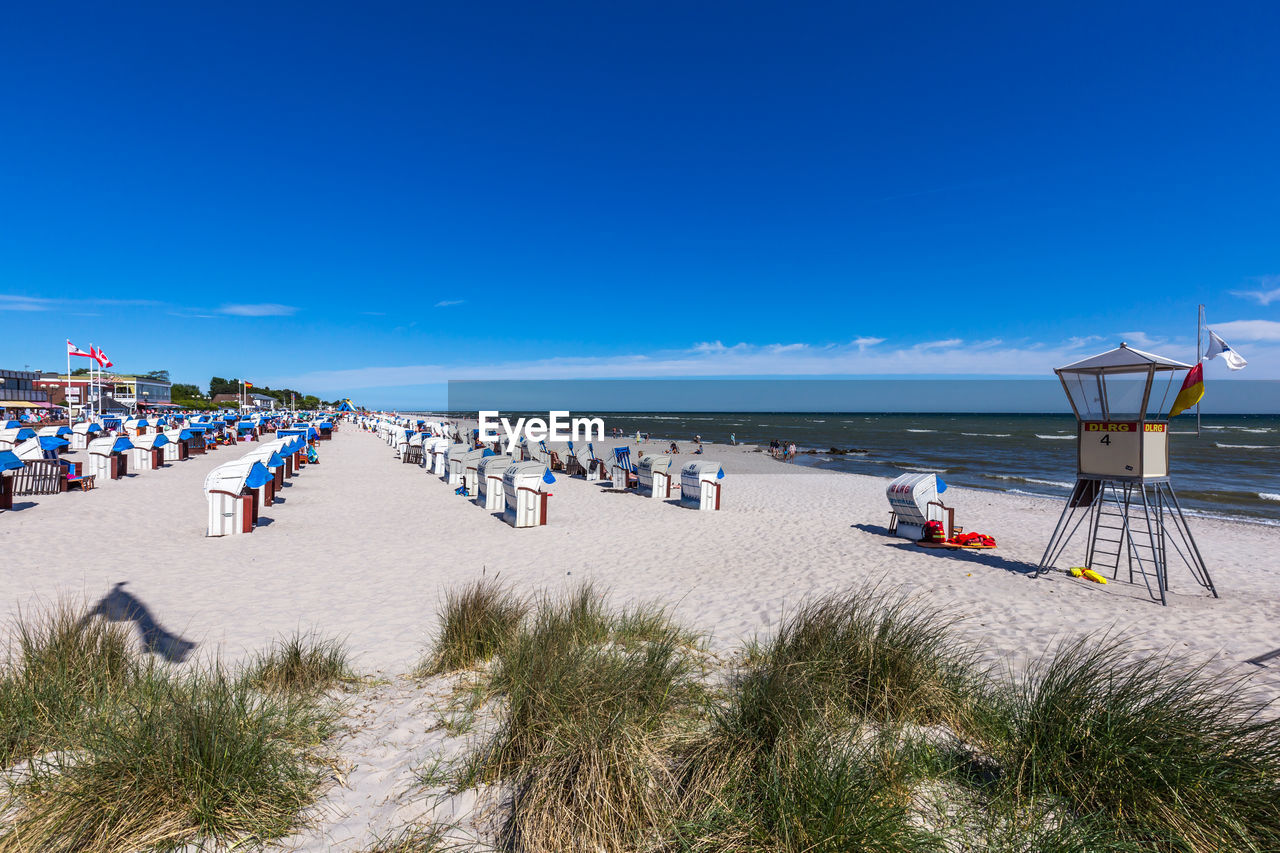 PEOPLE AT BEACH AGAINST BLUE SKY