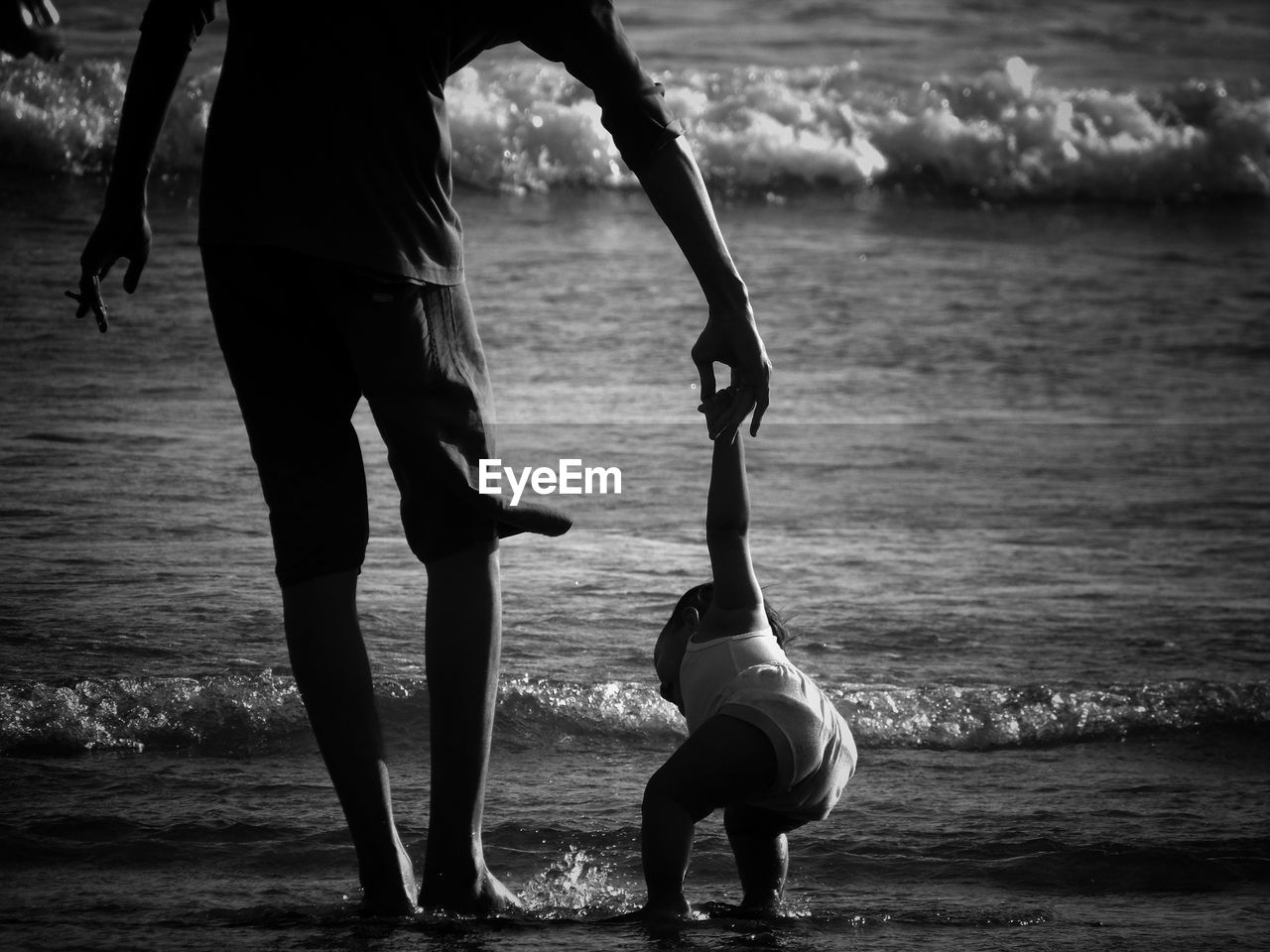 Rear view of man and holding child at beach