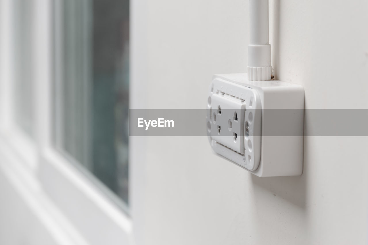 Close-up of electric outlet on wall at home