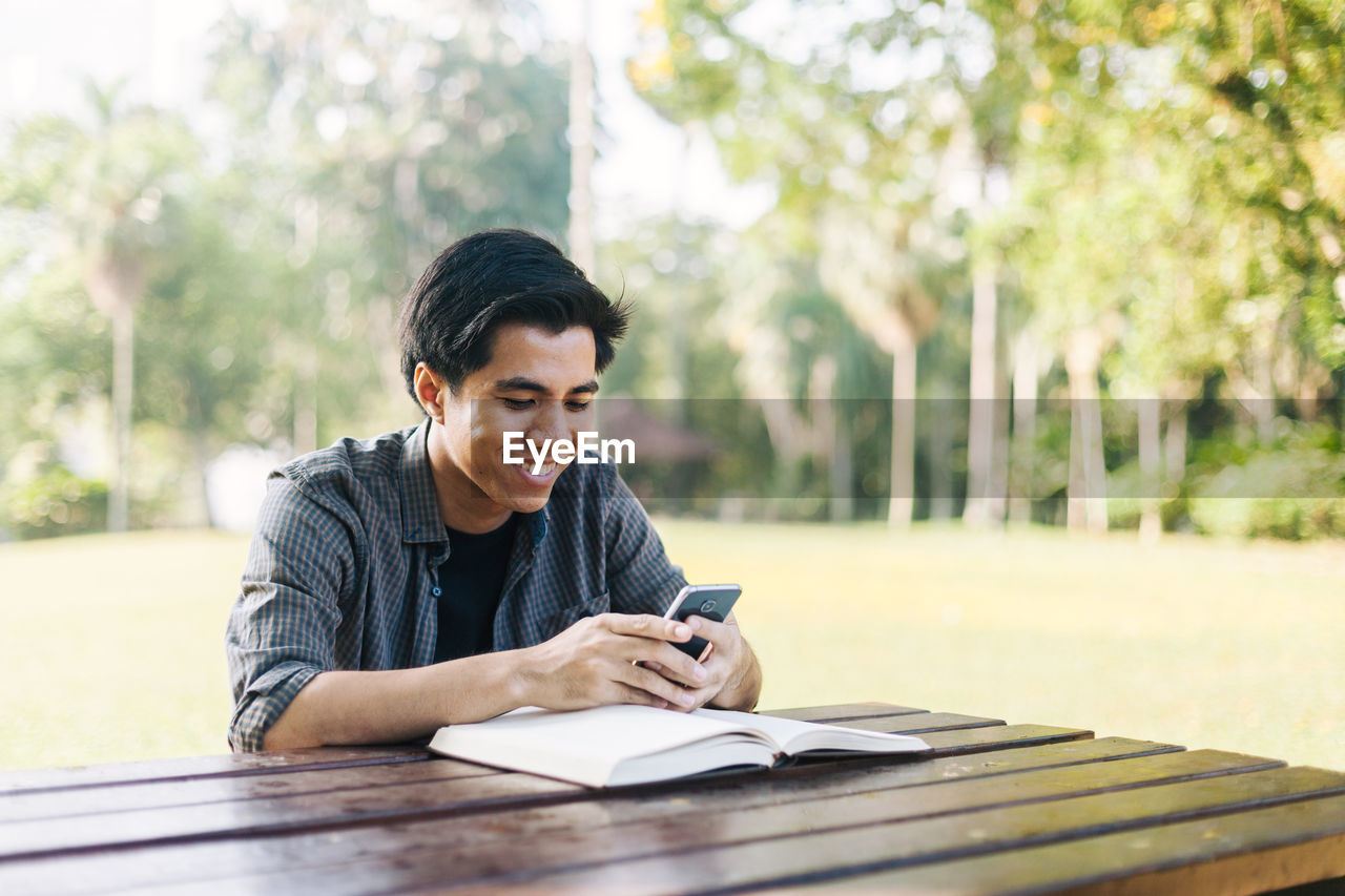 High angle view of man using phone while sitting at table