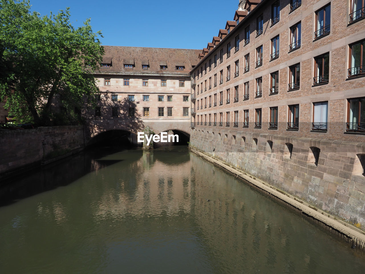 architecture, built structure, water, building exterior, waterway, canal, nature, building, city, travel destinations, moat, reflection, sky, history, tourism, travel, the past, bridge, clear sky, no people, residential district, day, body of water, outdoors, tree, waterfront, plant