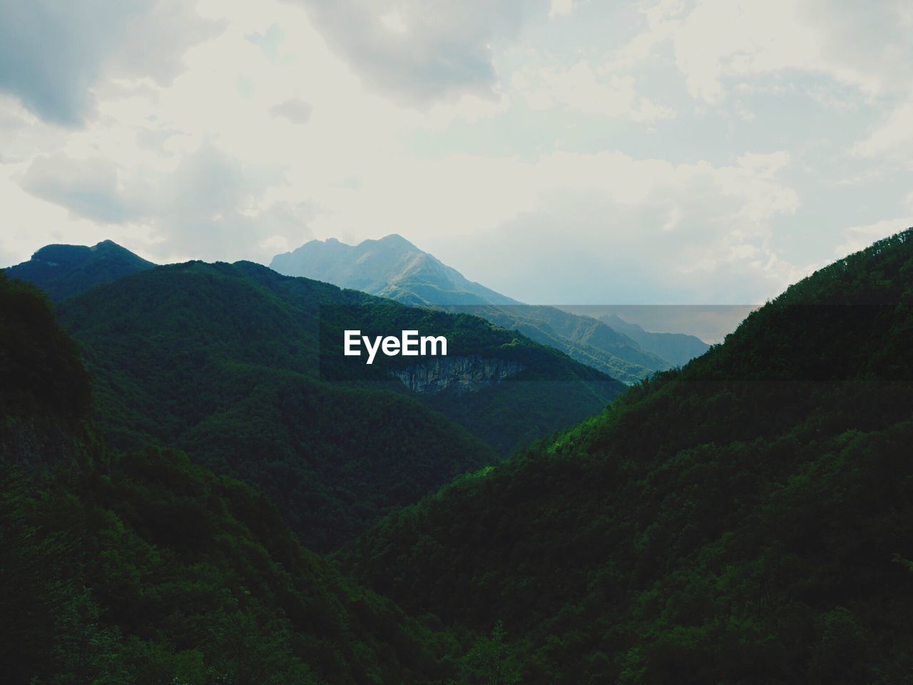 Scenic view of mountains against cloudy sky
