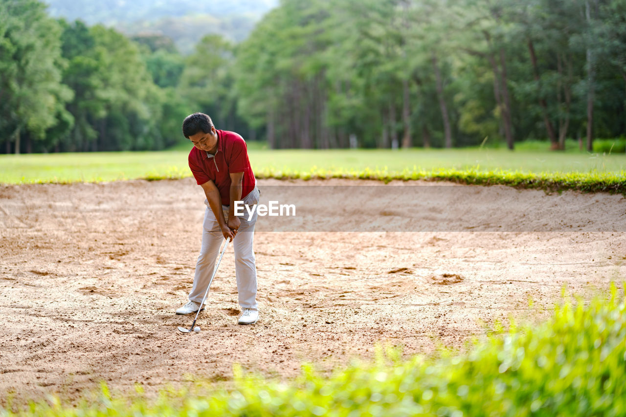 FULL LENGTH OF MAN PLAYING IN FIELD