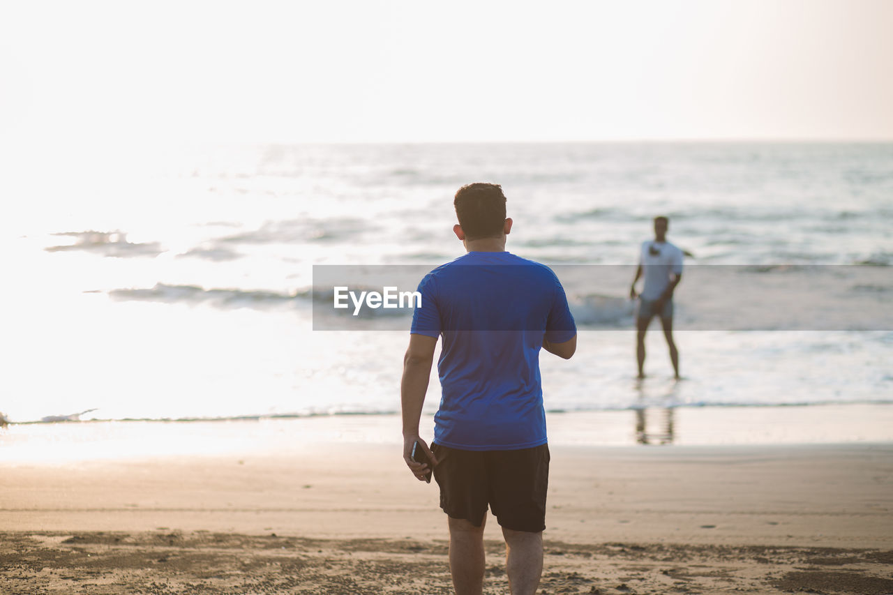 Two men standing on the beach