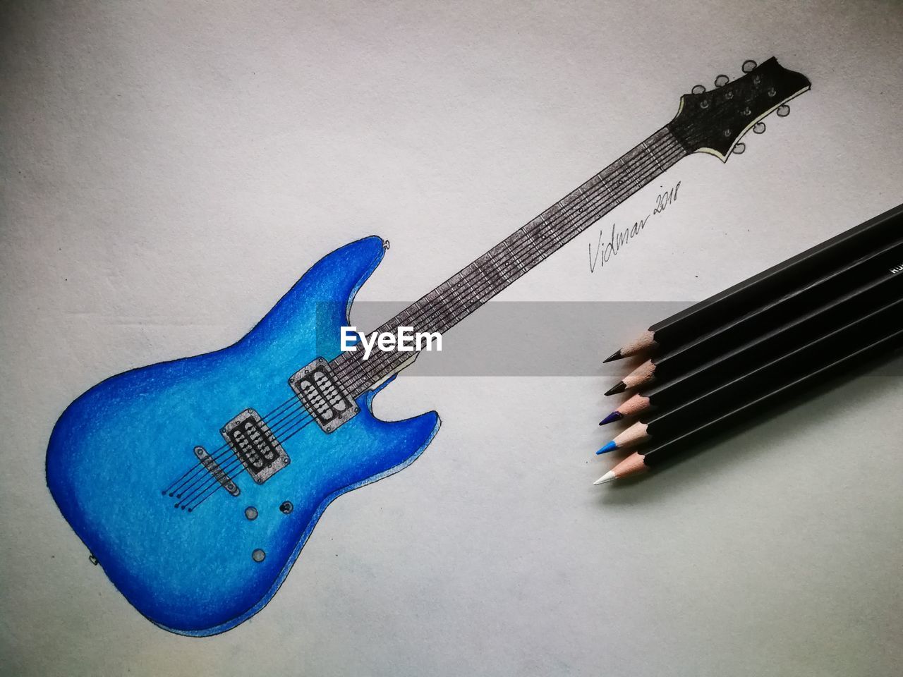 HIGH ANGLE VIEW OF GUITAR ON BLUE SHEET