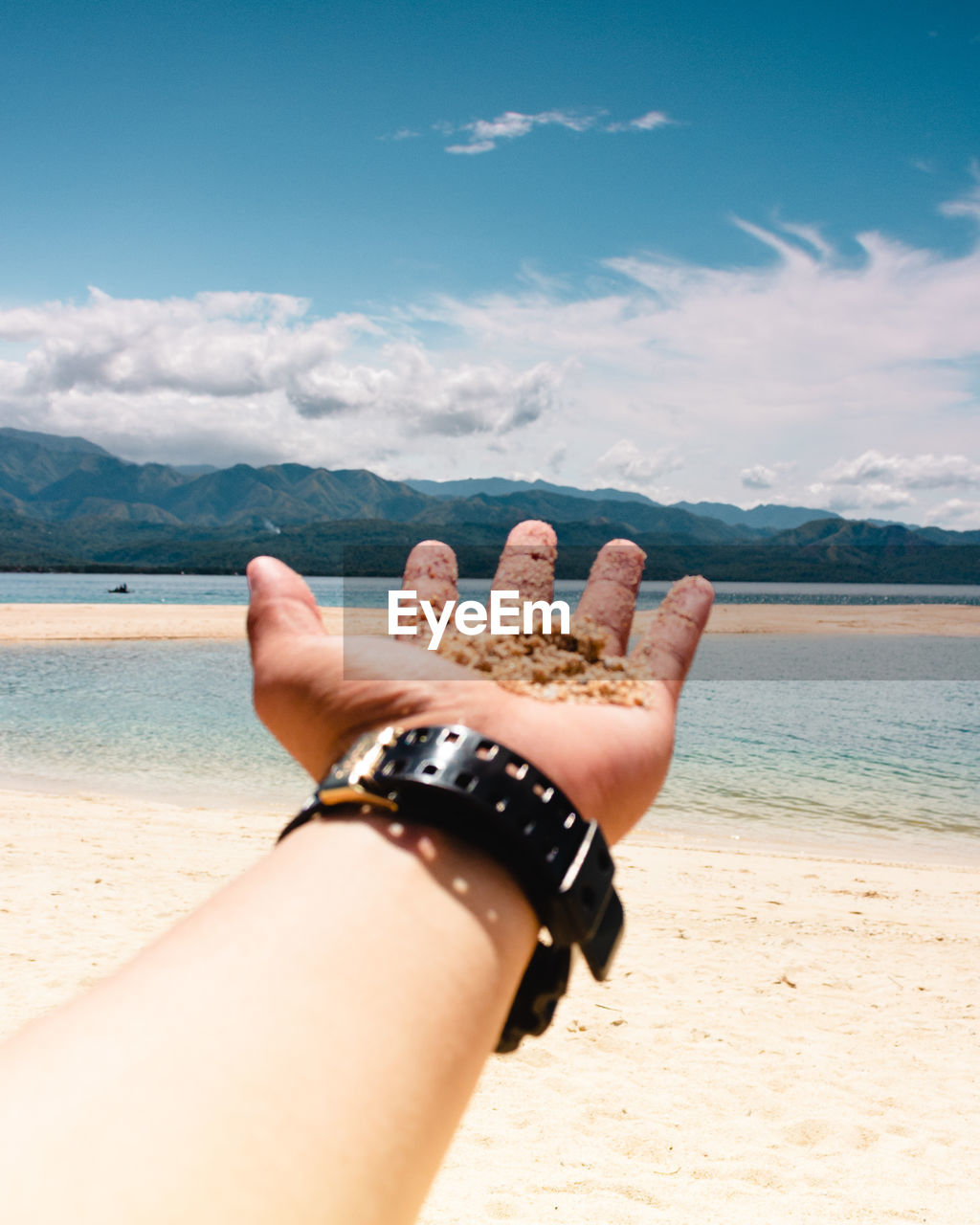 MIDSECTION OF WOMAN HAND ON BEACH