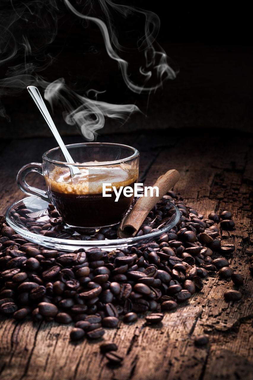 CLOSE-UP OF COFFEE BEANS IN GLASS ON TABLE