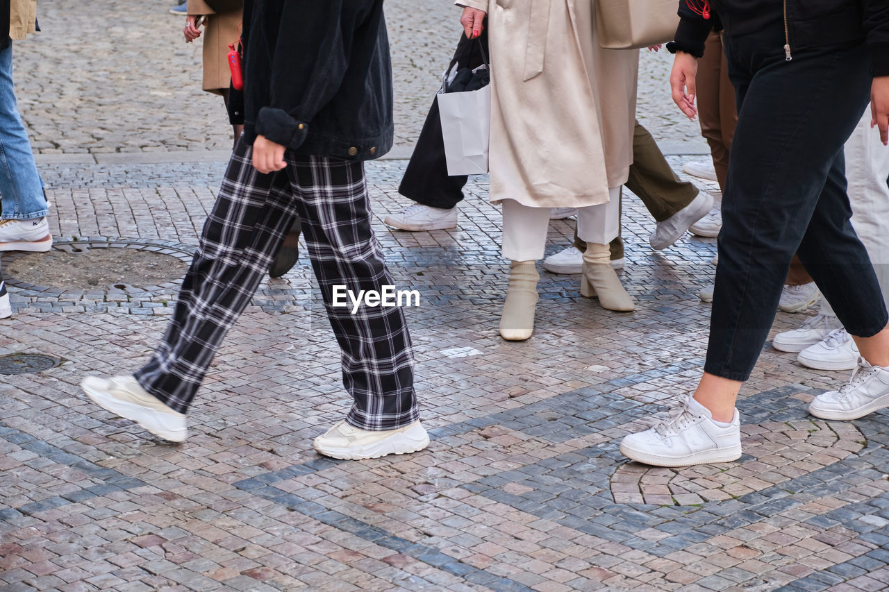 group of people, low section, clothing, human leg, footwear, women, spring, fashion, adult, shoe, street, city, lifestyles, men, limb, day, walking, human limb, togetherness, arts culture and entertainment, trousers, person, architecture, outdoors, group, footpath, standing, leisure activity, child, medium group of people, motion