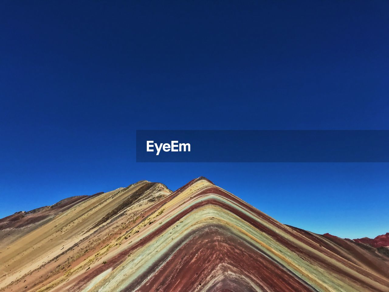 Low angle view of mountain against clear blue sky