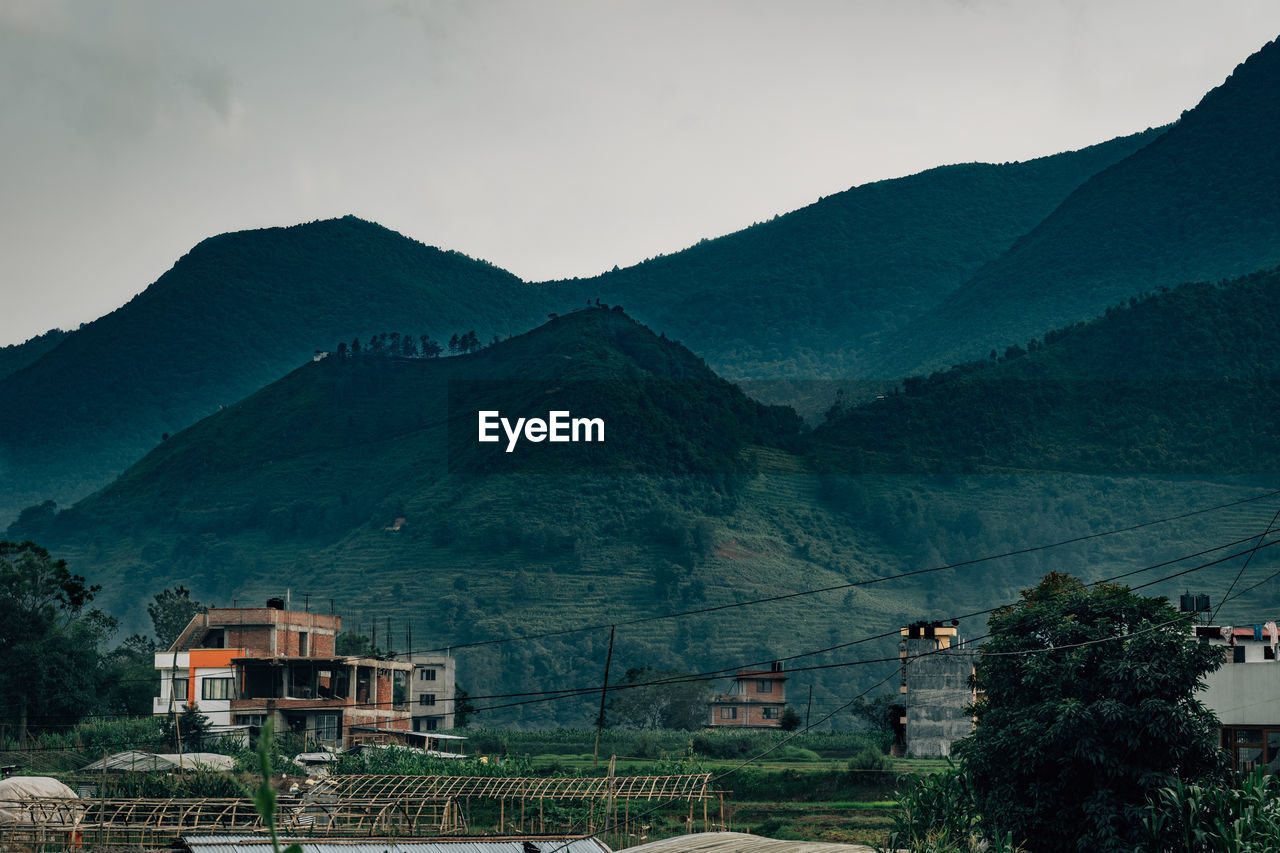 Scenic view of mountains and buildings against sky