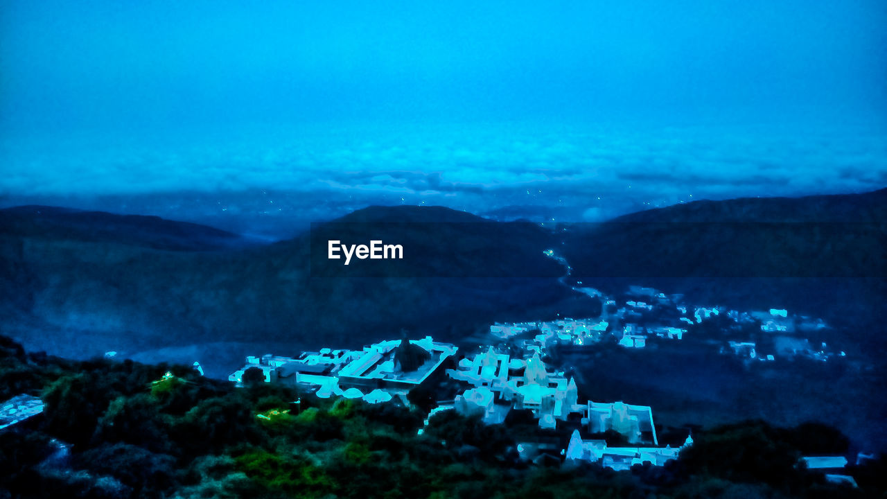 HIGH ANGLE VIEW OF BUILDINGS AND SEA BY MOUNTAIN