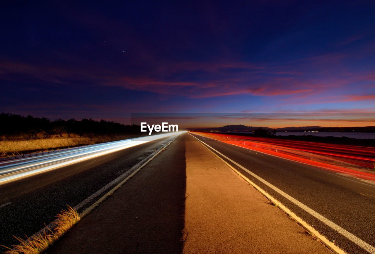 EMPTY ROAD AGAINST SUNSET SKY