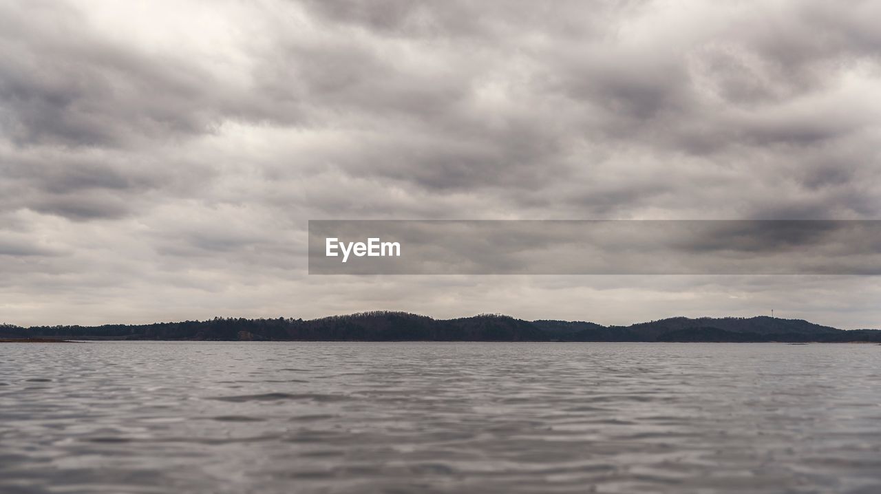 VIEW OF LAKE AGAINST CLOUDY SKY