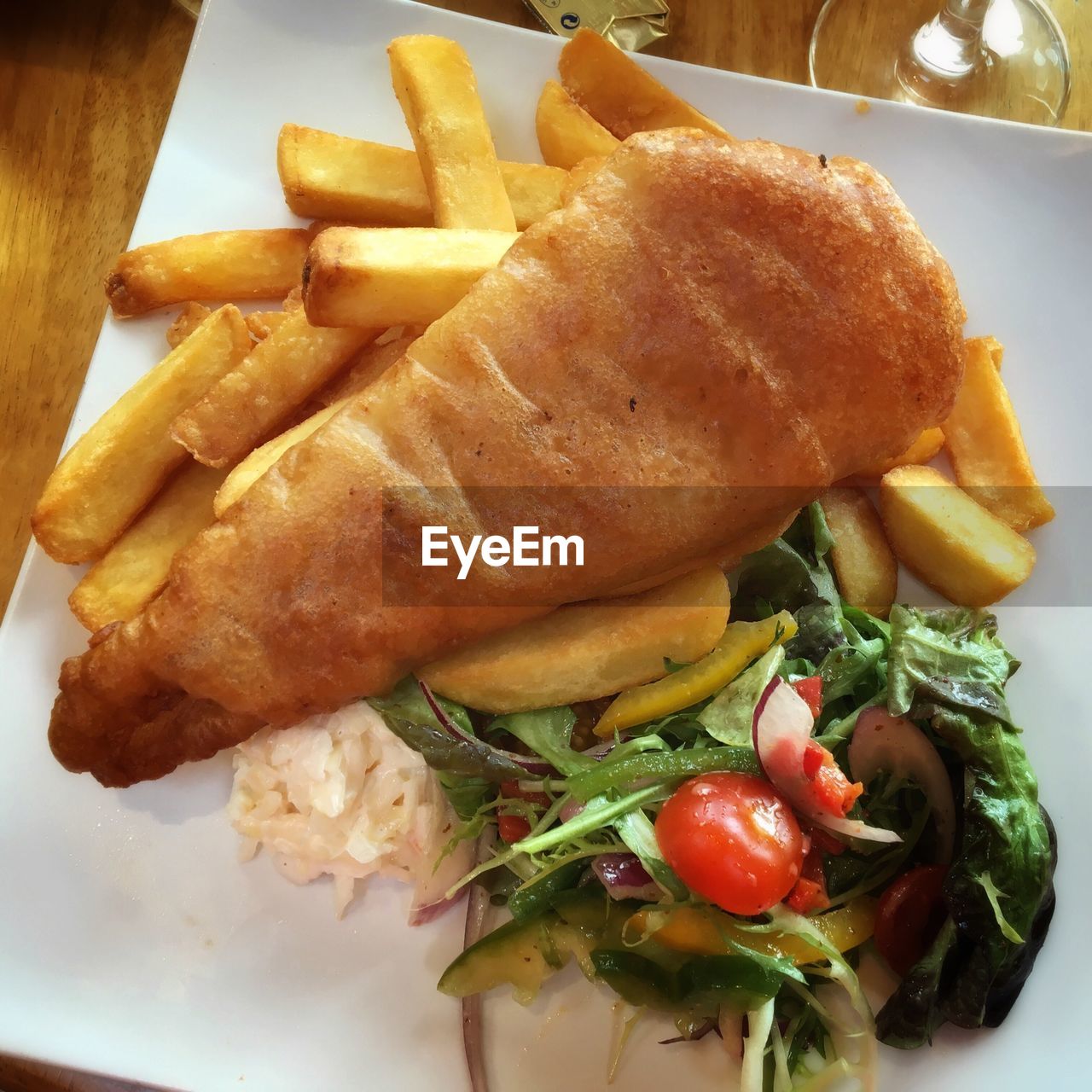 Directly above shot of fish with french fries and salad served in plate