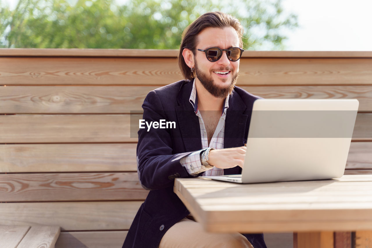 Portrait of businesswoman using laptop while sitting on table