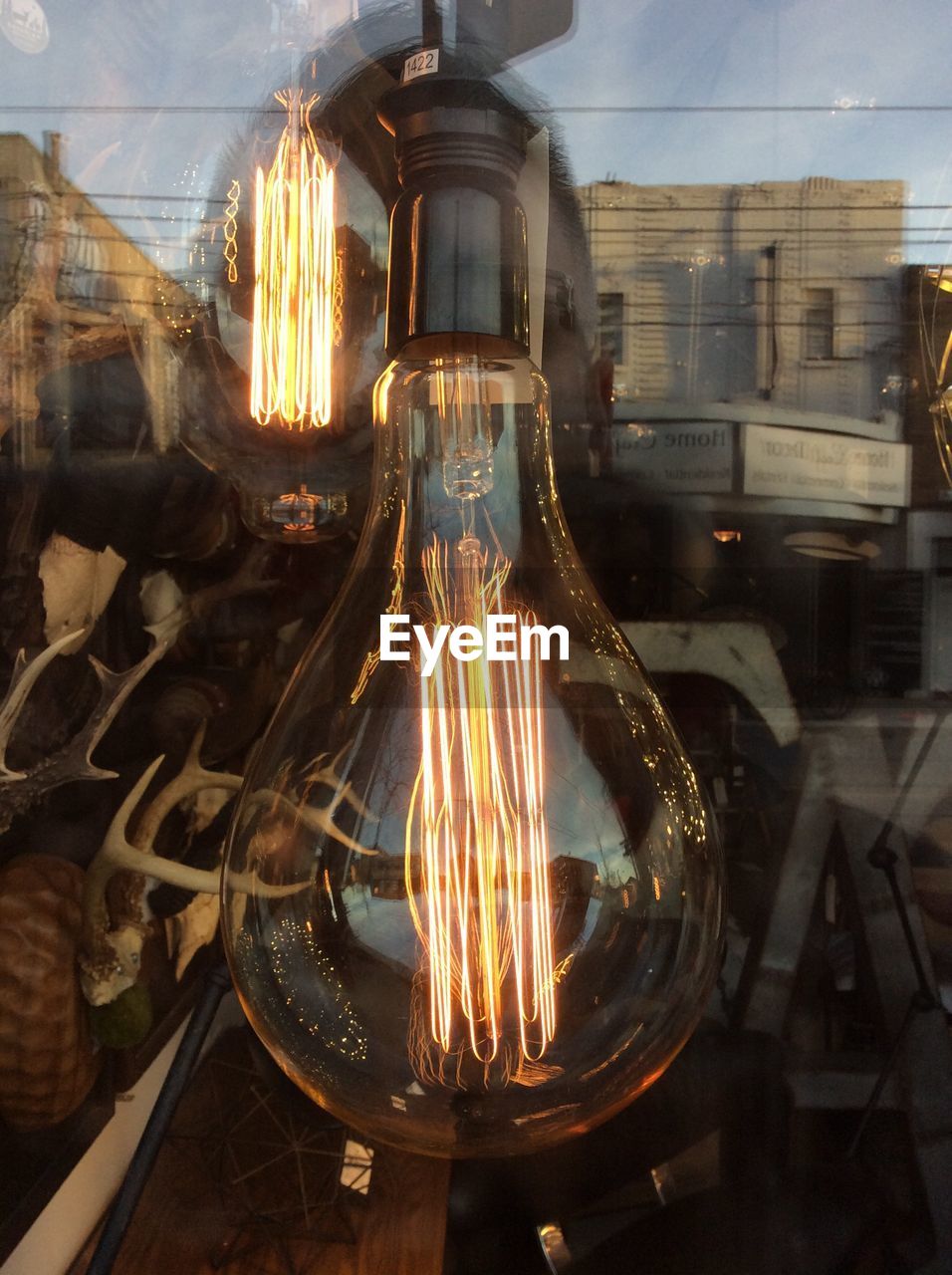 Close-up of illuminated vintage light bulb on window display