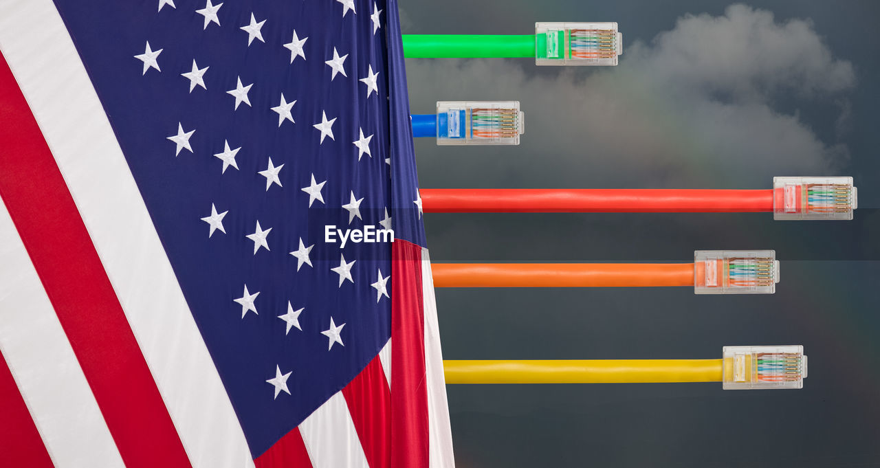 Digital composite image of cable with american flag against sky