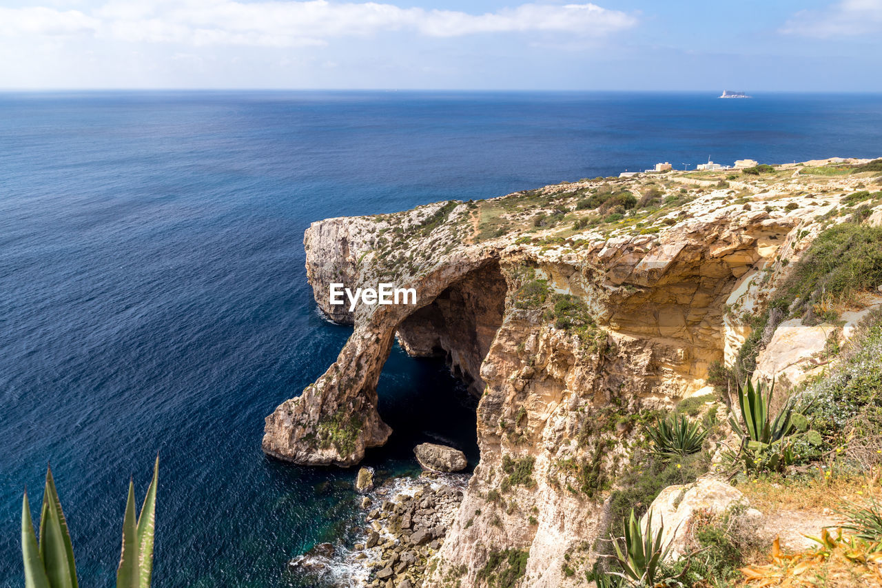 Scenic view of rock formation in sea against sky