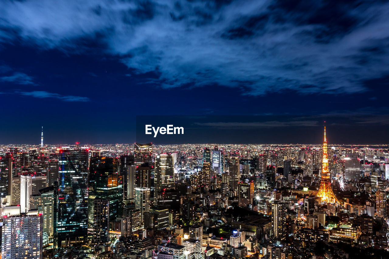 Illuminated cityscape against sky at night