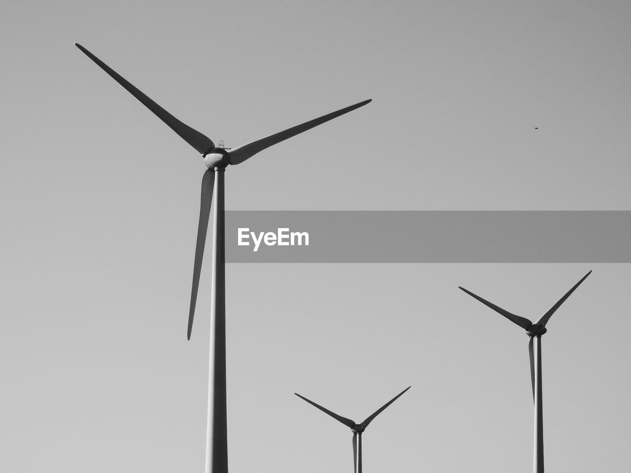 Low angle view of windmills against clear sky