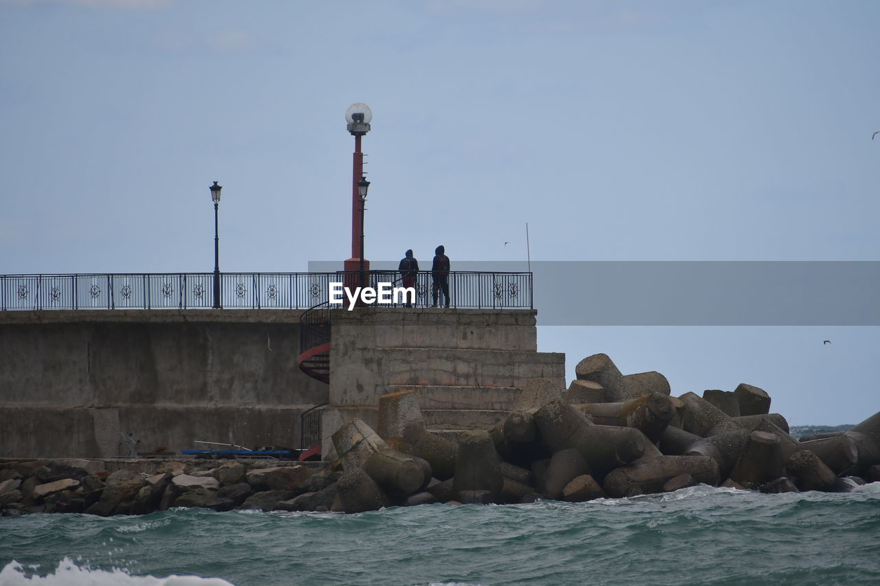 sea, water, coast, ocean, lighthouse, sky, nature, breakwater, shore, architecture, wave, animal themes, wildlife, animal wildlife, animal, built structure, mammal, day, outdoors, rock, group of animals, tower, vehicle, sea lion, beach, land, bay, travel, no people, pier