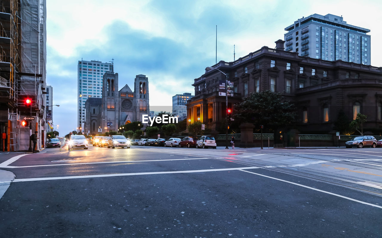 CITY STREET BY BUILDINGS AGAINST SKY