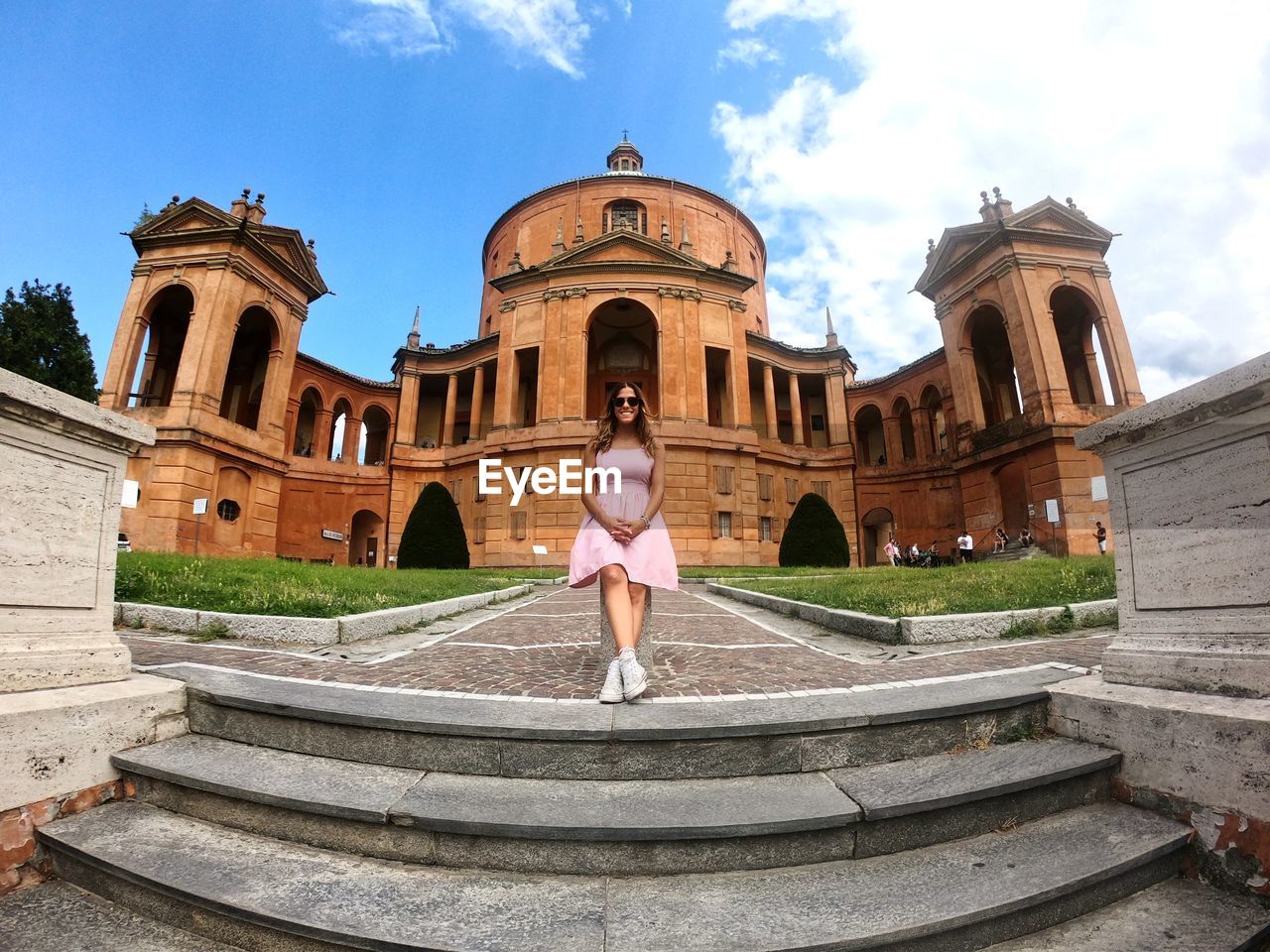 WOMAN STANDING AGAINST HISTORIC BUILDING AGAINST SKY