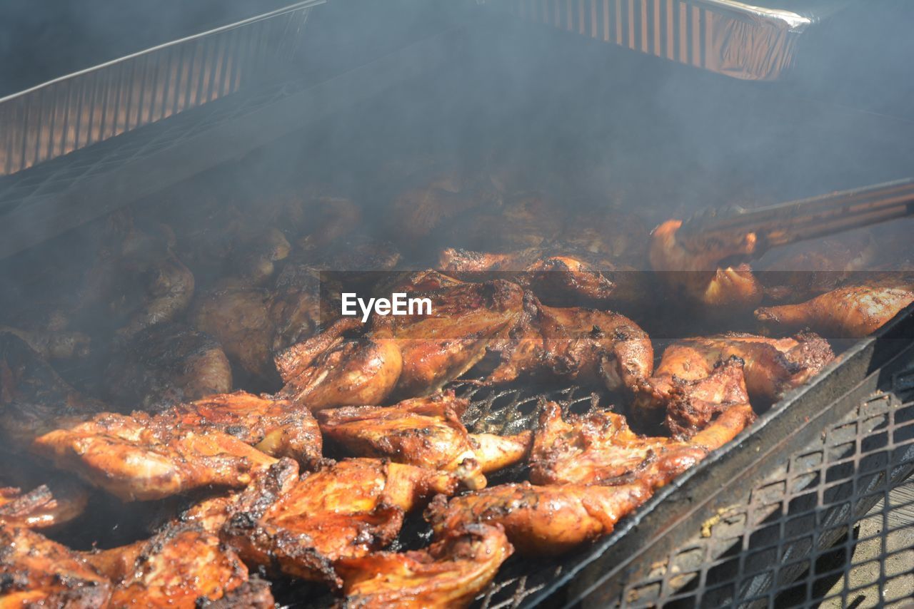 High angle view of chicken meat cooking on barbecue grill