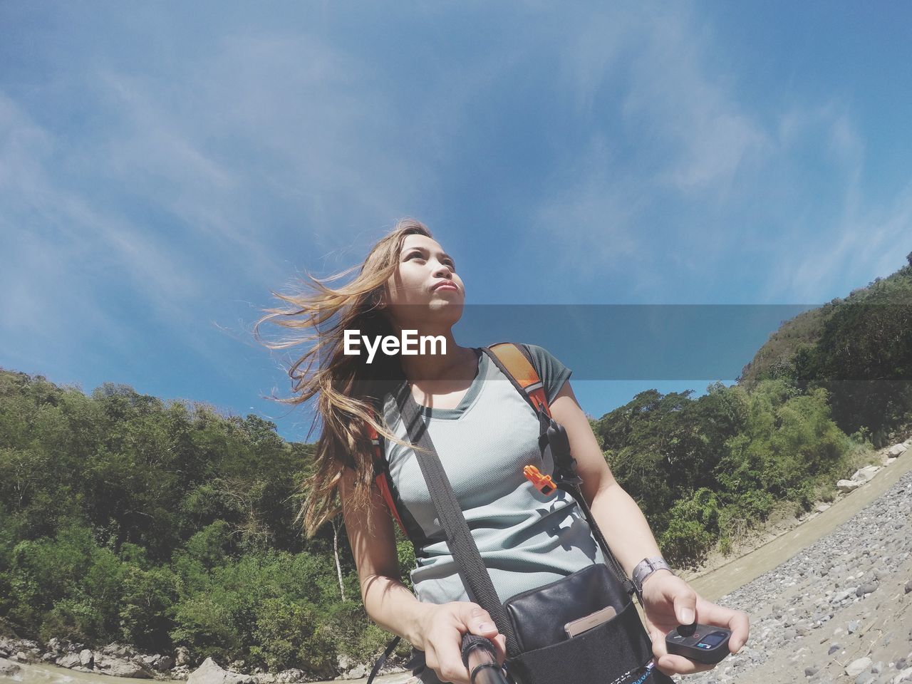 Low angle view of woman with backpack against sky