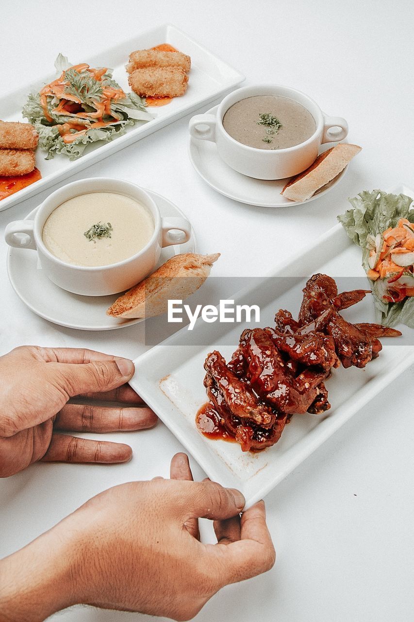 Cropped hands of person arranging food on table