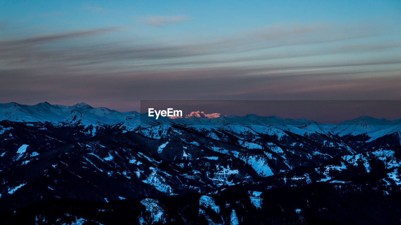 Scenic view of snowcapped mountains against sky during sunset