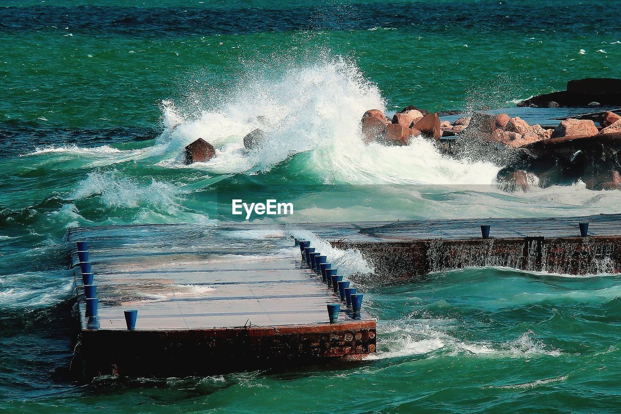 Waves splashing on sea against sky