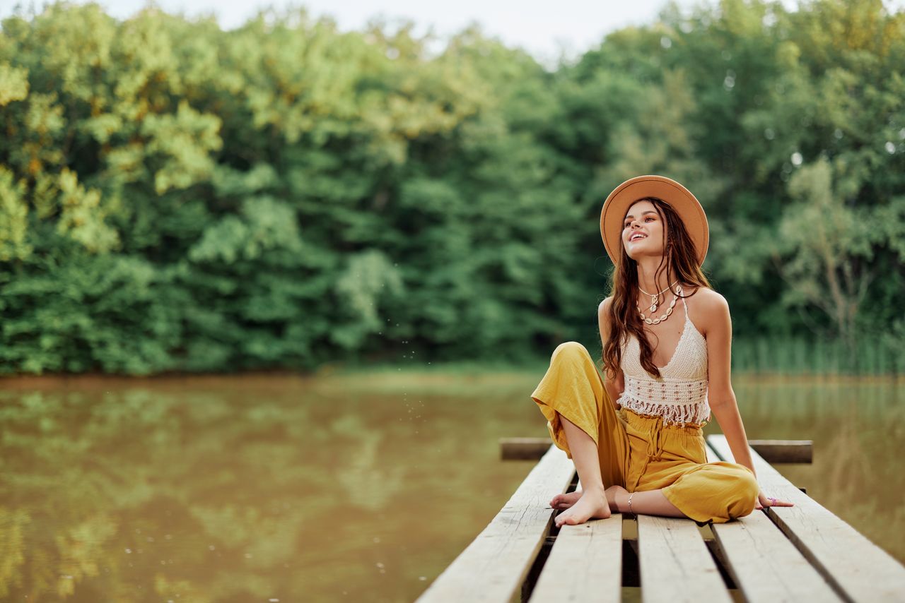 portrait of young woman standing against river