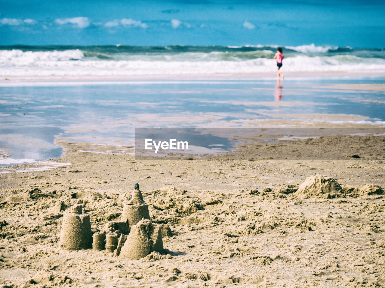 PEOPLE ON BEACH AGAINST SEA