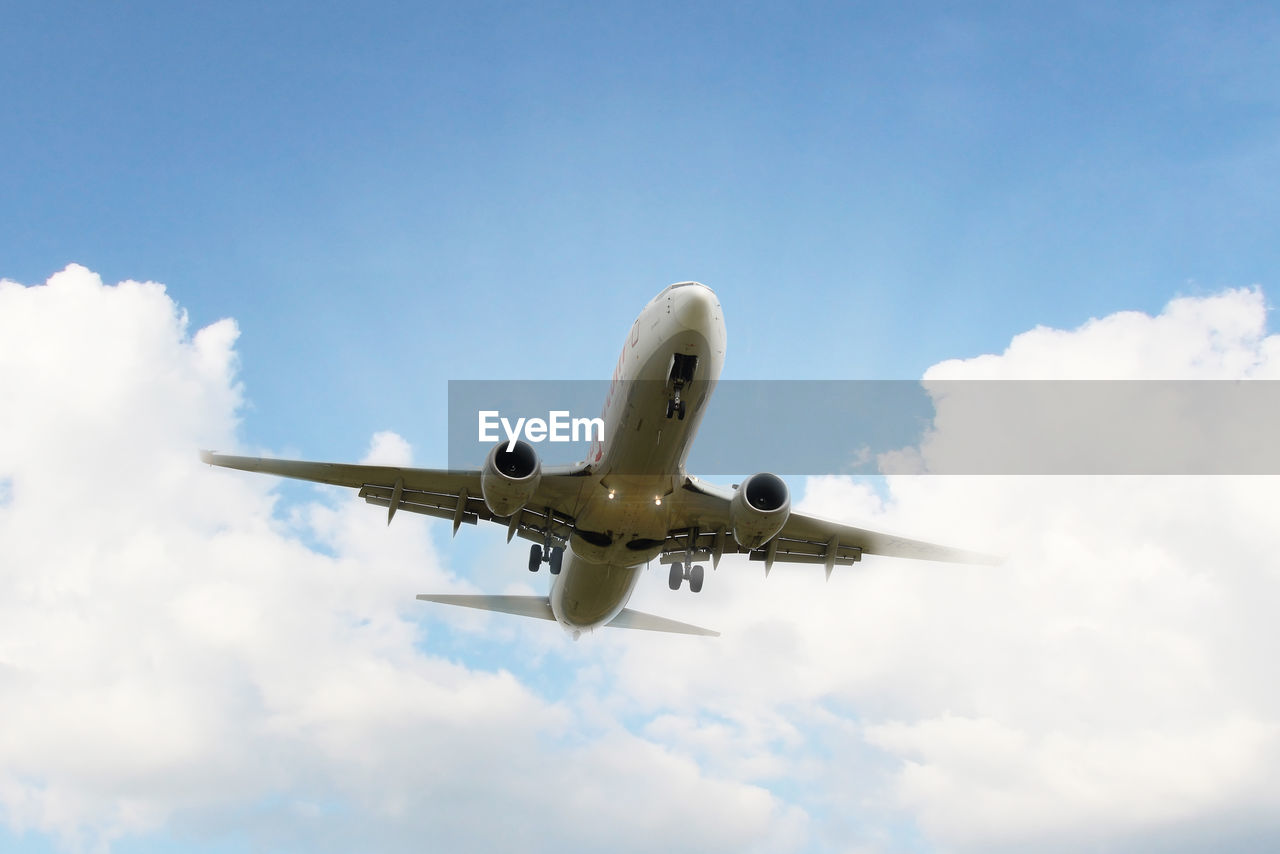 Airplane taking off under beatiful cloudy sky